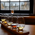 Flight of Scottish Whisky, Verkostungsgläser mit verschiedenen Single Malts oder Blended Whiskey Spirituosen auf einer Brennereibesichtigung in Schottland