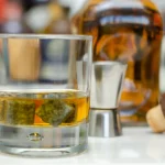 Old Fashioned Glas mit Scotch Whisky und Eiswürfeln auf der Bar